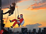 Vestidos de rena e Papai Noel, trabalhadores limpam janelas de um edifcio em Tqui, Japo