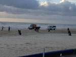 Equipe da prefeitura municipal recolhendo lixo na beira da praia. 