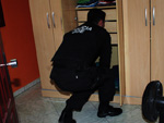 Polcia revira guarda-roupa  procura de drogas e armas.