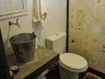 O lavabo entrou no clima de stio. O balde virou cuba, a bancada  de cimento queimado e a parede foi revestida com azulejos antigos reaproveitados