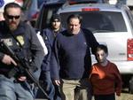 NEWTOWN, CONNECTICUT, EUA, 14/12/2012: Um pai e seu filho deixam a rea da escola primria Sandy Hook acompanhado por policiais, onde um atirador abriu fogo nesta sexta-feira, matando pelo menos 27 pessoas.