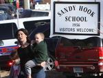 NEWTOWN, CONNECTICUT, EUA, 14/12/2012: Uma mulher retira crianas da rea da escola primria Sandy Hook acompanhado por policiais, onde um atirador abriu fogo nesta sexta-feira, matando pelo menos 27 pessoas.