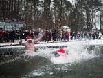 Nadadores com roupas de papai noel na gua fria durante tradicional natao no gelo em Lanke, Berlim.