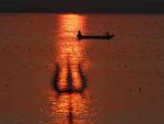 Foto tirada no sbado (22) mostra um tridente contra o reflexo do sol na interseco entre os rios Ganges e Yamuna, na na ndia.