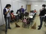 Serventes de escola no Bairro Passo Manso usam mscaras contra poeira de rua em frente  unidade