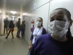 Serventes de escola no Bairro Passo Manso usam mscaras contra poeira de rua em frente  unidade