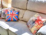 As almofadas estampadas e coloridas sobre o sof, todas compradas em sites de e-comerce pela internet, fazem aluso  bandeira do Reino Unido