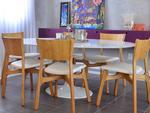 Contornam a mesa criada por Eero Saarinen Saarinen, umas das poucas concesses a peas icnicas de design, as cadeiras Ceiba, obras do designer Eduardo Baroni, feitas de cinamomo natural