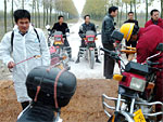 Mdicos preventivos desinfetam veculos na cidade de Shishou, China, onde casos de gripe aviria foram encontrados