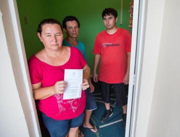 Erni mostra a carta da prefeitura ao lado do marido, João Francisco (C), e do filho, neto de Zilá, Jeferson Almeida