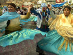Personagem tradicional do carnaval boliviano, &quot;chuta&quot;, desfila entre duas mulheres em de La Paz