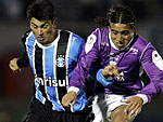 Patricio (E), do Grmio, disputa a bola com Mauro Villa, do defensor. O Grmio est em busca de saldo de gols, para depender de vitria simples no Olmipico