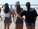 Meninas passeiam na beira da praia