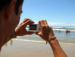 Veranista fotografa na beira da praia