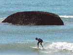 Pedra do Careca e surfistas fazem parte do visual da Praia da Joaquina