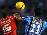 O meia colorado D'Alessandro sobe para disputar a bola com Willian Magrão