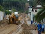 Homens trabalham na retirada da lama na rua Netuno em Blumenau