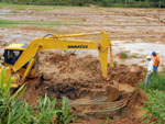 Retroescavadeira retira terra decorrente de deslizamento em plantao de arroz em Gaspar