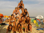 As garotas construram uma pirmide humana na praia