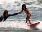Papai surfista aproveita para ensinar a filha no domingo ensolarado do Litoral Norte