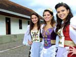 A rainha Caroline Scoppel (centro) e princesas Camila Baggio (E) e Aline Vanzin