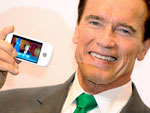 Schwarzenegger posa com um dos celulares apresentados na feira