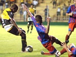 O atacante Zulu chuta e zagueiro d carrinho para evitar o gol