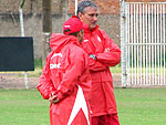 O tcnico Tite (atrs) e o auxiliar Clber Xavier observam o treino no gramado suplementar