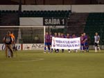 Jogadores do Marclio Dias entram com uma faixa em homenagem aos 90 anos do clube