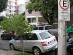 Veculo est estacionado na faixa amarela e com uma placa com horrios determinados para o estacionamento