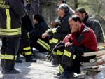 Bombeiros e membros dos servios de resgate descansam em L'Aquila