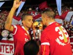 Taison e D'Alessandro beijam o trofu do bicampeonato gacho invicto