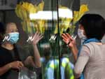 Hong Kong - Uma turista hospedada no hotel Metropark acena para uma amiga do lado de fora. O hotel foi isolado pela polcia depois da confirmao de que uma mexicana vtima da gripe suna esteve hospedada l.