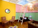 Paredes coloridas e mveis em miniatura compem o ambiente interno do castelo, como as cadeirinhas e os pequenos estofados de couro sinttico. Escada de ferro pintado de branco leva ao mezanino da morada de brincadeiras