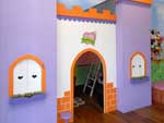 Projetado no vo da escada e convertido em casinha de bonecas, o castelo ganha janelas em arco na fachada e mveis em miniatura na parte interna