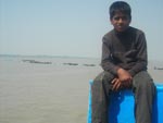 Menino trabalha em barco que faz a travessia do Rio Pusur no Sundarbans, o maior manguezal do mundo   