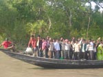 Barcos cruzam lotados a rea do maior manguezal do mundo, o Sundarbans, atravs do Rio Pusur  