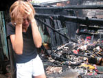 A dona de casa do bairro Salgado Filho olha o que sobrou, depois de o fogo ser controlado pelos bombeiros, da casa onde morava. Ela se desespera. Flagrante de 5 de fevereiro de 2003