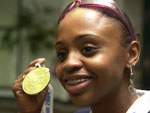 Em seu retorno a Porto Alegre, a atleta olmpica exibe medalha no aeroporto Salgado Filho