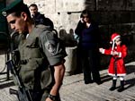 F em Deus e nos presentes: a pequena, travestida de Mame Noel, chega para missa na Igreja do Santo Sepulcro, em Jerusalm