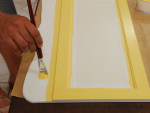 Passo 5: depois de limpar o pincel n 20 na gua, use-o para pintar a moldura, laterais e a parte inferior do cabideiro com a tinta amarelo claro. Espere secar.