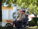 Idoso e vendedor de algodo doce descansam na praa Coronel Bertaso, no centro de Chapec