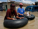 Indonsios levam seus pertences em cima de pneus pelas ruas inundadas da cidade de Java. Milhares de pessoas tiveram que evacuar suas casas por causa de enchentes do rio